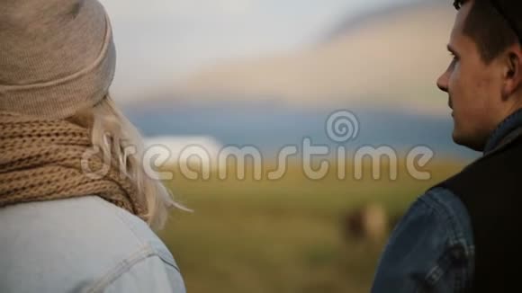 年轻漂亮的夫妇站在田野上说话女人用手指着向男人展示一些东西视频的预览图