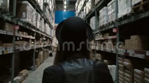 后景年轻时尚的女人骑着购物车在大仓库高货架独自享受乐趣视频的预览图