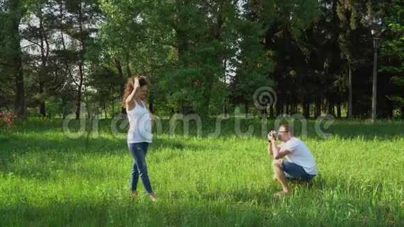 帅哥在公园用相机拍年轻快乐孕妇的照片视频的预览图