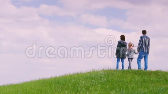 一家三口人爸爸妈妈和女儿6岁站在一座青山上期待着视频的预览图