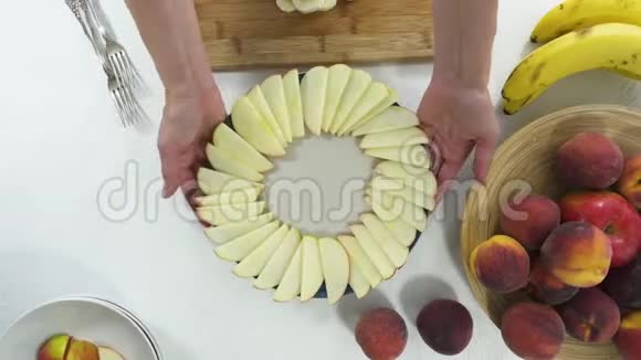 苹果片和香蕉片在盘子里安排水果拼盘的女人视频的预览图