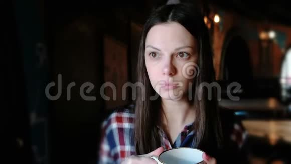 布鲁内特女士穿着格子衬衫从一个大杯子里喝茶累的女人喝茶视频的预览图