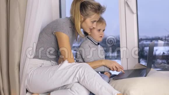 可爱的女儿和她妈妈用电脑视频的预览图