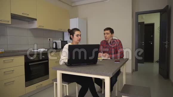 女孩和男孩坐在笔记本电脑前谈论家庭事务视频的预览图