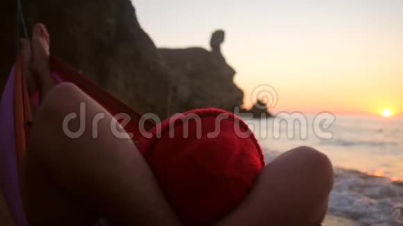 希普斯特徒步旅行者在沙滩上的吊床上放松欣赏令人惊叹的金色日落景色1920x1080视频的预览图