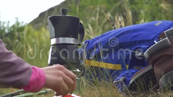 一个女孩在山上的天然间歇泉咖啡机上用煤气炉煮咖啡视频的预览图