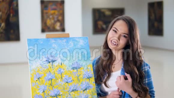 肖像艺术家微笑着站在一张花的照片附近视频的预览图