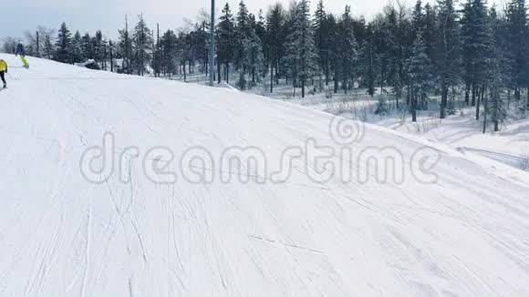 冬季人们在针叶林附近的滑雪道上近距离观看滑雪坡和滑雪板录像滑雪视频的预览图