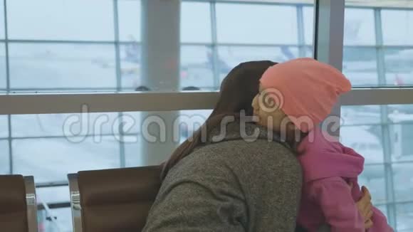 母亲和可爱的小女儿在机场慢动作地轻轻拥抱视频的预览图