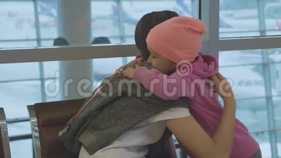 母亲和可爱的小女儿在机场慢动作地轻轻拥抱视频的预览图
