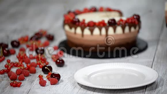 一块美味的三块巧克力慕斯蛋糕上面装饰着新鲜的浆果视频的预览图