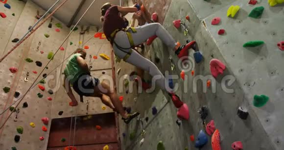 男人和女人在巨石健身房爬人造墙4k视频的预览图