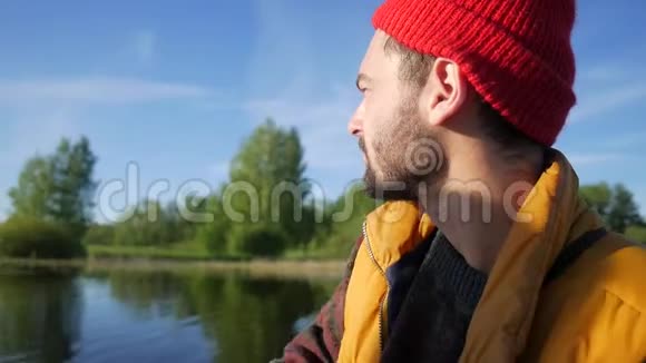 年轻的白种人在一个夏天美丽的湖上眺望远方高清慢镜头视频的预览图