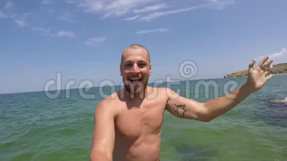 小胡子男人从岩石上跳进水里制作自拍视频慢动作视频的预览图