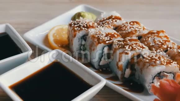 大而漂亮的白色寿司卷配上鳗鱼黄瓜费城奶酪姜芥末和一片日本柠檬视频的预览图