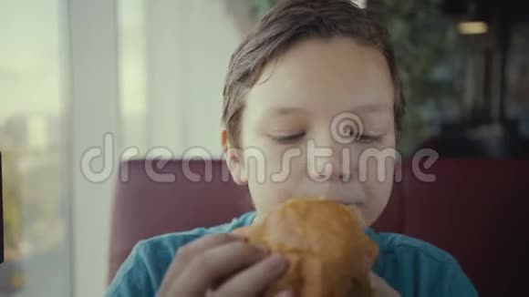快乐的青少年在快餐店吃美味的汉堡视频的预览图