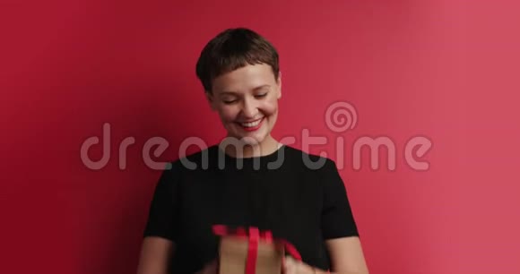开心微笑的女人扔礼物盒视频的预览图