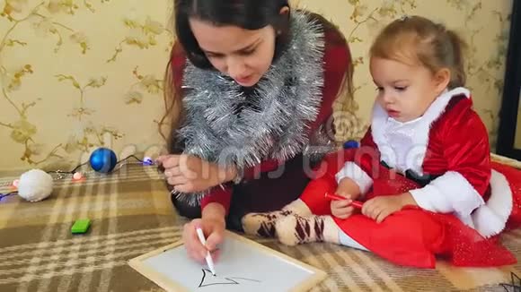 妈妈带着女儿在黑板上画圣诞节的属性妈妈和女儿正在画一棵圣诞树圣诞节主题视频的预览图