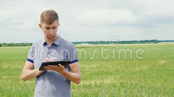 一位年轻成功的农民正在田间劳作摘要绿色模糊背景视频的预览图