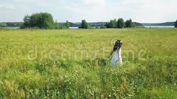自由概念空中观景穿裙子的女孩走在田野上视频的预览图
