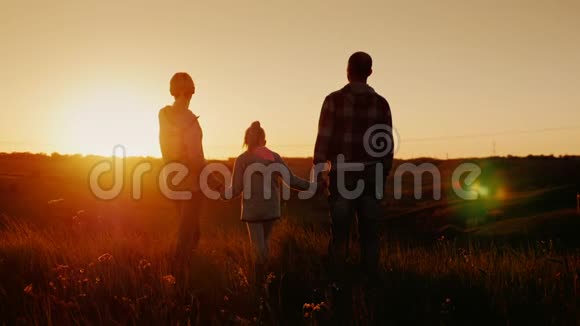 年轻的家庭期待着日落的地平线妈妈爸爸和女儿在一起视频的预览图