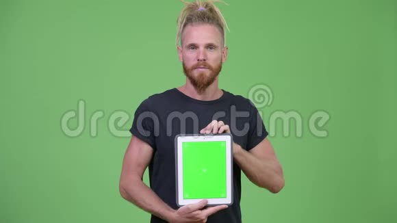 快乐英俊的长胡子男人带着看数字平板电脑的恐惧症视频的预览图