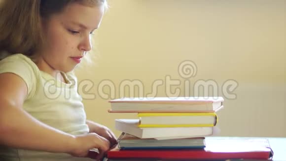 一个悲伤的女孩坐在一堆书上愤怒地推开他们拿起电话网瘾他微笑着视频的预览图