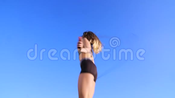 性感漂亮的金发女郎运动型女孩女人金发长发穿着黑色短裤日落时跳绳视频的预览图