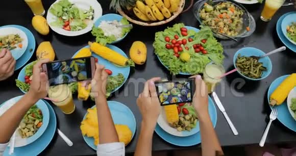 以手机智能手机顶部视角拍摄健康素食照片的人组坐着吃饭的朋友视频的预览图