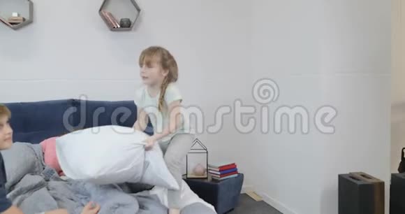 有枕头的孩子和熟睡的父母在床上打架幸福的家庭在卧室的早晨视频的预览图