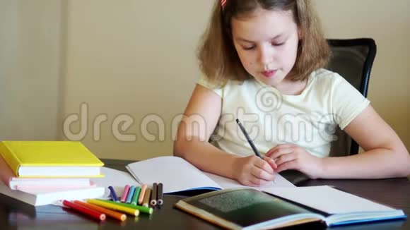 女学生做作业桌子上有课本练习本和铅笔回学校去准备工作视频的预览图