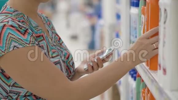 女人用手机选择超市里的家庭用品视频的预览图