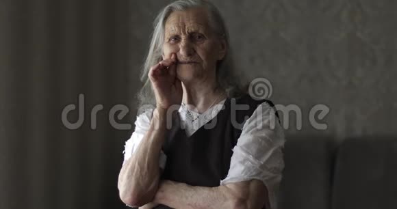 一位长着灰色长发的祖母手指靠近她的下巴说话视频的预览图