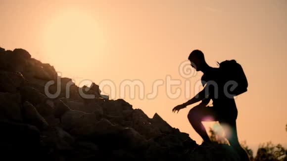 日落时一个背着背包的人上升到山顶日落时那个人的剪影健康活动视频的预览图