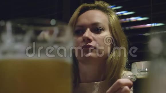 一个女人在夜总会喝着一杯黑啤酒视频的预览图