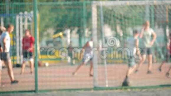 小男孩在球门旁边的运动场上踢足球男孩在阳光明媚的日子踢足球视频的预览图