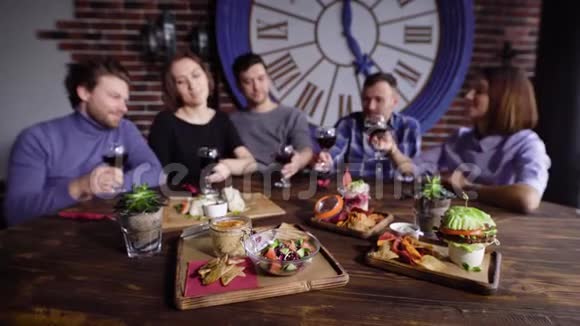 朋友在餐厅庆祝周年纪念的情景他们愉快地在酒杯中着酒和端上的食物视频的预览图