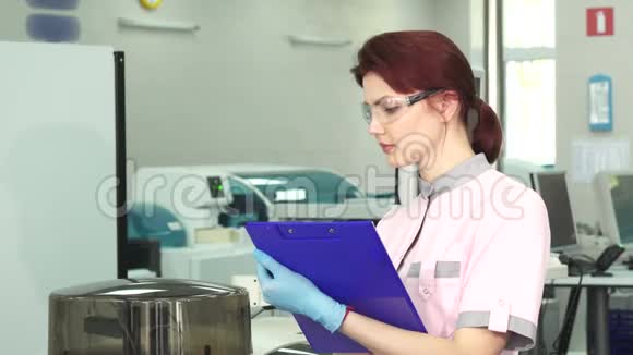年轻的女科学家在现代实验室做笔记视频的预览图