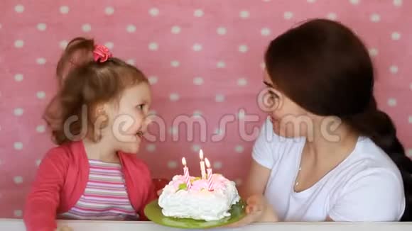 快乐的妈妈和孩子许愿在聚会上吹灭生日蛋糕上的蜡烛母亲祝贺拥抱和视频的预览图