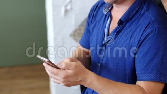 一个白人男子拿着一部手机一部智能手机看着它打字而女孩纹身大师迈亨迪艺术家视频的预览图