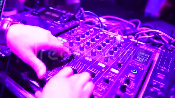 DJ手在DJ甲板上调整各种轨道控制装置视频的预览图