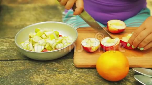 女性的手被切成块与桃子一起做水果沙拉视频的预览图