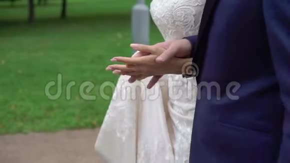 室外新娘和新郎手牵手在公园散步视频的预览图