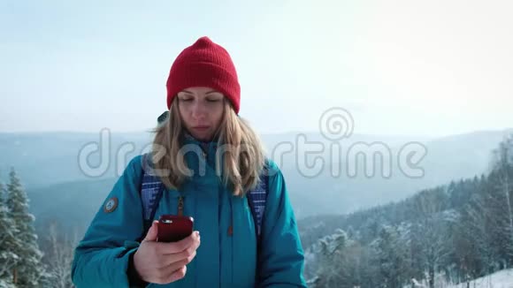 年轻女孩游客在冬天在智能手机上做照片自拍使用智能手机旅行的快乐旅游女孩视频的预览图