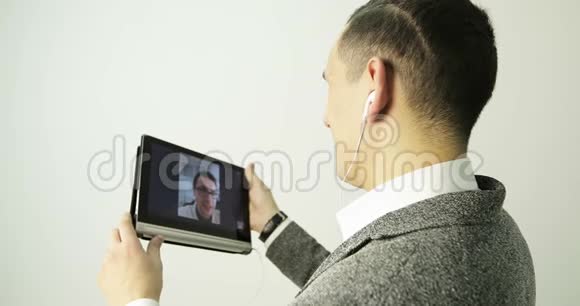 帅哥用平板电脑和耳机打电话视频的预览图