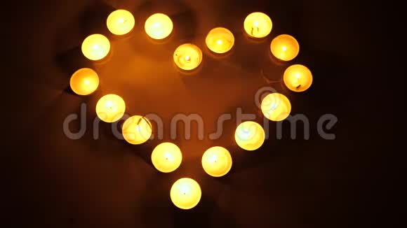 心形态燃烧的茶灯茶点燃蜡烛形成心脏的形状爱的主题概念视频的预览图