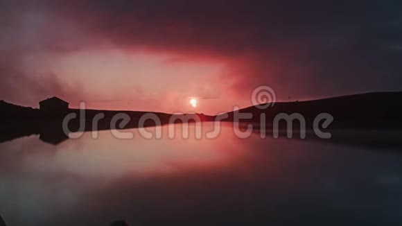 一个名为山眼的湖上日出的时间推移形成了一片粉红色的天空视频的预览图