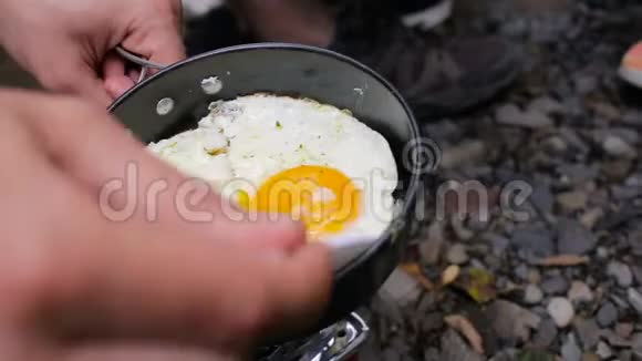 游客在露营地吃早餐男人手给女游客倒鸡蛋视频的预览图