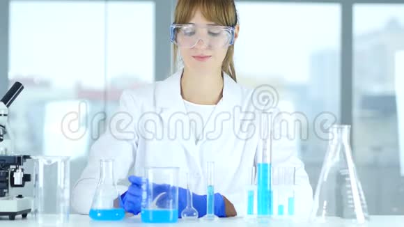女研究科学家在实验室里观察烧杯中的溶液reacti视频的预览图