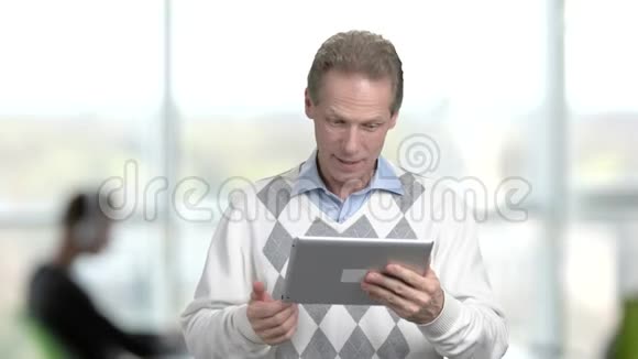 成熟的经理通过个人电脑平板电脑交谈视频的预览图